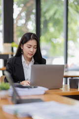 Business Asian woman working with laptop computer and calculator document on an office desk, doing planning analyzing the financial report, business plan investment, finance analysis concept.
