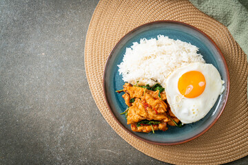 stir-fried fried fish with basil and fried egg topped on rice