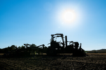 Carcasse de tracteur calciné suite à un incendie dans le champ de chaume lors de forte canicule