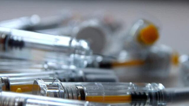 Bunch of injection syringes as vaccinations doses and booster vaccination dose for covid-19 vaccine prevention and medical treatment with experimental drugs pharmaceutical wealth with 3rd mrna vaccine - Powered by Adobe