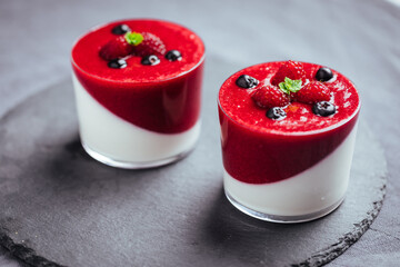 Panna cotta dessert with sauce from berries. Cherries, raspberries and blueberry as decoration....