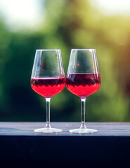 Two glasses of red wine on a table against a blurred background