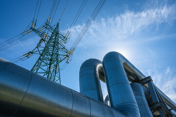 Industrial pipelines on pipe-bridge against blue sky