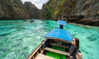 Beautiful women relax on the boat in Beautiful sea and blue sky at Phi phi island - obrazy, fototapety, plakaty
