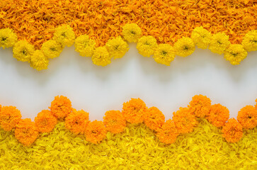 Decorative yellow and orange color marigold flowers and petals rangoli for Diwali festival with white space background.