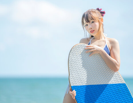 Japanese girl in bikiny stay on the beach and swimming pool