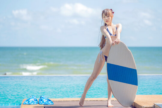 Japanese girl in bikiny stay on the beach and swimming pool