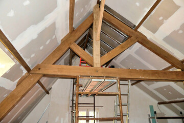 Plasterboard fitted over new roof insulation highlighting exposed beams and trusses
