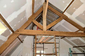 Obraz premium Plasterboard fitted over new roof insulation highlighting exposed beams and trusses 