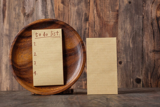 notepad with to do list in wood plate on kitchen table at home