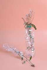 Flowers on a transparent plastic bottles. Polyethylene Film. Plastic pollution and environmental problem.