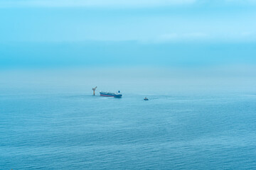 Obraz premium foggy seascape with a tanker near an oil terminal located far out to sea