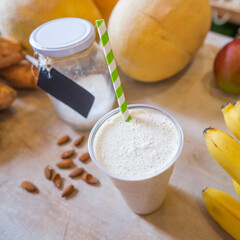 Healthy protein shake on table with fruits and vegetables ingredients around.