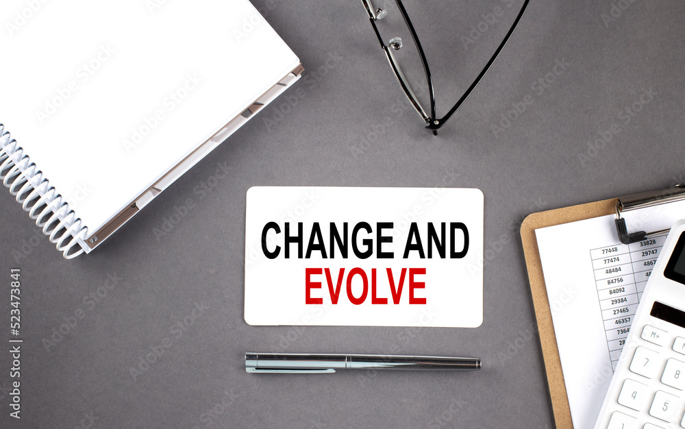 Aufkleber change and evolve text written on the card with notebook and clipboard, grey background