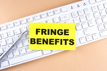 Text FRINGE BENEFIT text on a sticky on keyboard, business concept