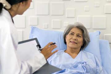 Young asian doctor examine the symptom of the elderly patient in the recovery room. Healthcare and medicine concept