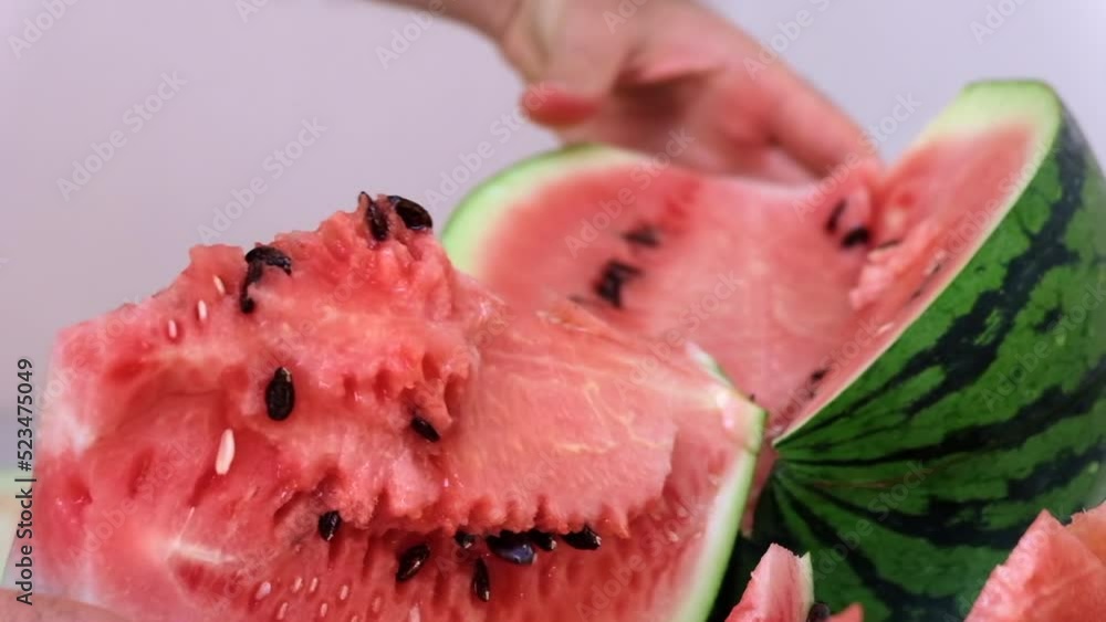 Wall mural Man cutting a red ripe watermelon