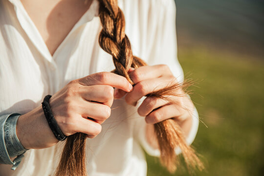 Young woman braiding her hair