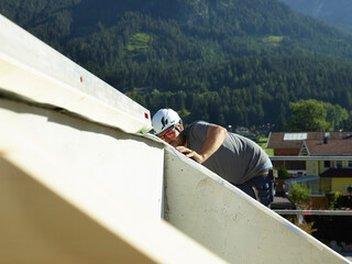 Craftsperson in hardhat working at construction site on sunny day