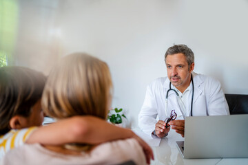 Doctor with mother and son in medical practice