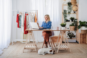 Young fashion designer working on laptop at home office