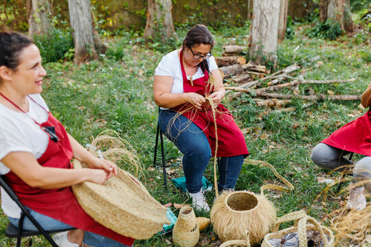 Artisans weaving baskets with esparto grass in garden