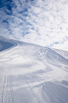 Ski tracks on snow under cloudy sky