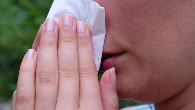 Woman suffering from hay and ambrosia allergy, red itchy nose