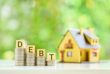 Real estate debt fund and household debt, financial concept : Wood cubes with the word DEBT on top of 4 coin stacks with a two story model house. Real estate debt funds focus on commercial real estate - obrazy, fototapety, plakaty