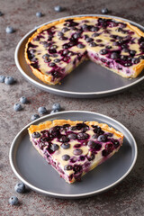 Sliced Mustikkapiirakka Finnish Blueberry Pie close-up in a plate on a table. Vertical
