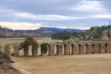 view of viaduct arch bridge near small village in turkey