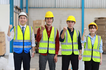 Group of technician engineer and businessman in protective uniform with hardhat standing and raising hands celebrate successful together or completed deal commitment at industry manufacturing factory