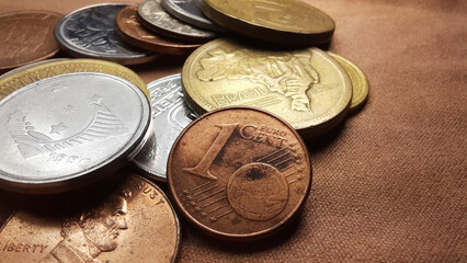 1 Euro cent coin with a collection of various old coins on a brown background.