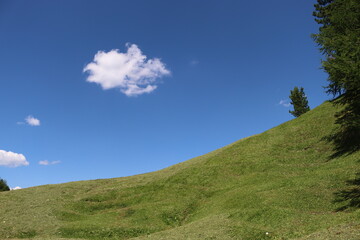 Val Badia, Italy-July 17, 2022: The italian Dolomites behind the small village of Corvara in summer days with beaitiful blue sky in the background. Green nature in the middle of the rocks.