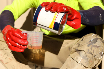 Work place health safety industrial painter wearing red chemical safety protection glove while...