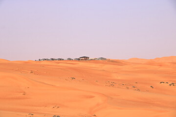 Fototapeta na wymiar Bedouin style camping beside a huge sand dune at the Wahiba Sands desert, Oman.