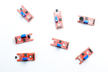 Arduino DIY modules on a white background. Selective focus. Red PCB. Blue potentiometers. Technological concept. Top view.