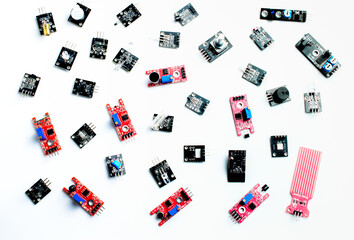 Arduino DIY modules on a white background. Selective focus. Red and black PCB. Blue potentiometers....