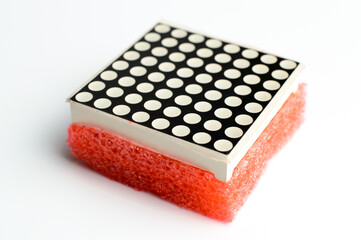 8x8 led matrix in a red foam-sponge. Led matrix composition on isolated white background. 