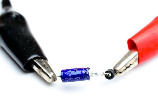 Electronic capacitor explosion. Close up photo. Background picture. Concept of malfunction and failure. Black and red crocodiles.