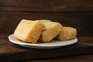 Jadah Goreng or Fried sticky rice cake is Javanese traditional cake made from glutinous rice and grated coconut. Served in white plate, selective focus image.
