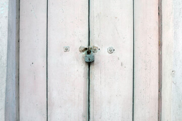 Hinged barn lock on an old wooden door