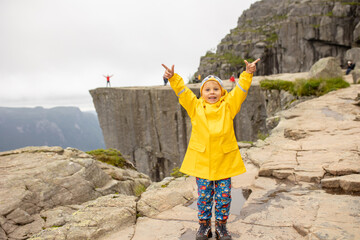 Family, enjoying the hike to Preikestolen, the Pulpit Rock in Lysebotn, Norway on a rainy day,...