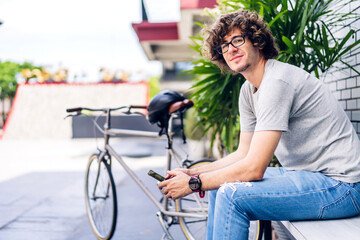 Portrait of smiling happy confident casual hipster young handsome man enjoying and relax look at camara.successful caucasian guy sit at the street city.businessman and travel