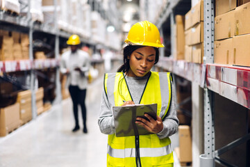 Portrait african american engineer woman shipping order detail on tablet check goods and supplies on shelves with goods inventory in factory warehouse.logistic industry and business export