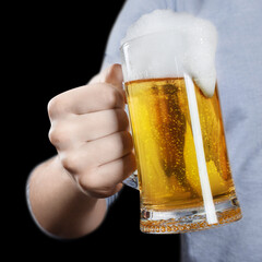Glass of excellent beer in male hand, isolated on black background