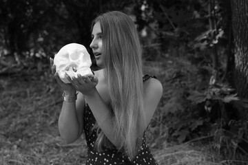 Woman holding human skull in hands 