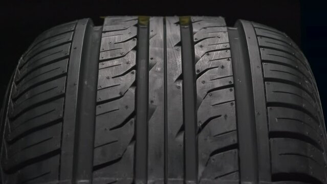 Season for Winter Tires. The concept of seasonal tire replacement. Close-up new car wheel slowly spinning. A cold weather warning sign appears on the tread side of the wheel