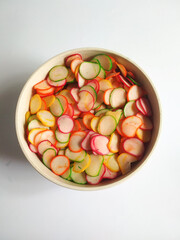 Colorful onion flavored raw crackers isolated in bowl with a white background