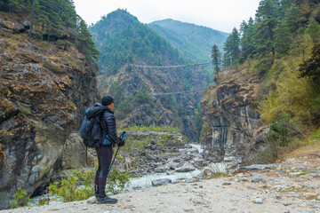 Tourist man looking to Tenzing-Hillary Suspension Bridge, the bridge build for crossing the river...